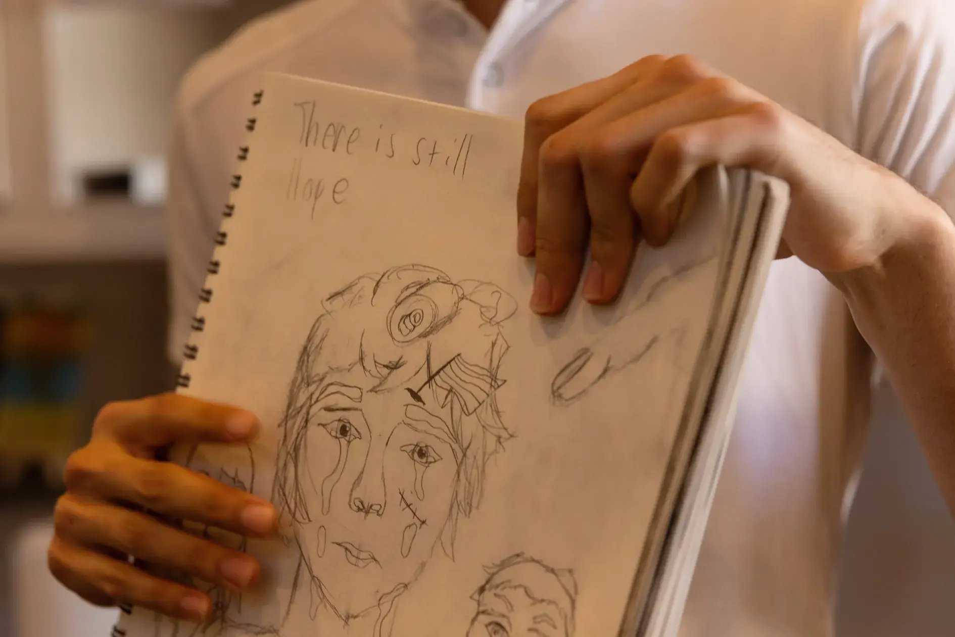 Meza showing one of his drawings that reflect his struggle with schizophrenia.