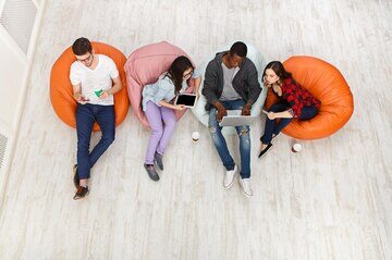 coffee-break-young-people-with-devices-group-multiethnic-young-students-preparing-exams-bean-bag-chairs_116547-11871